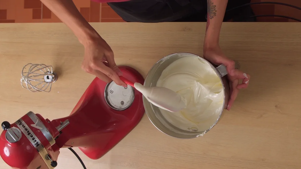 Cena da aula de buttercream: espátula retirando a cobertura da tigela da batedeira
